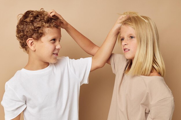 Garçon et fille se tenant par les cheveux fond beige