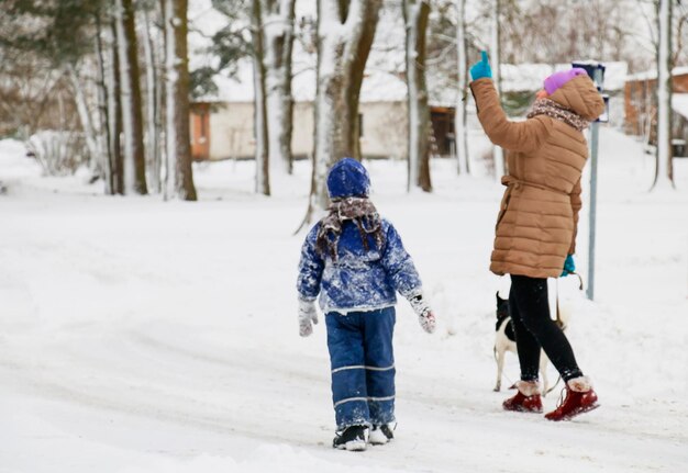 Garçon avec une fille suivre une route d'hiver