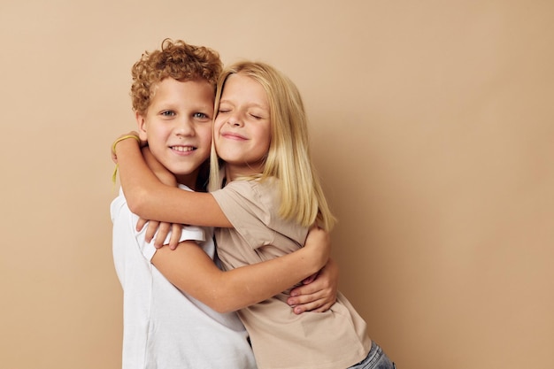 Garçon et fille en t-shirts câlins amitié fond beige