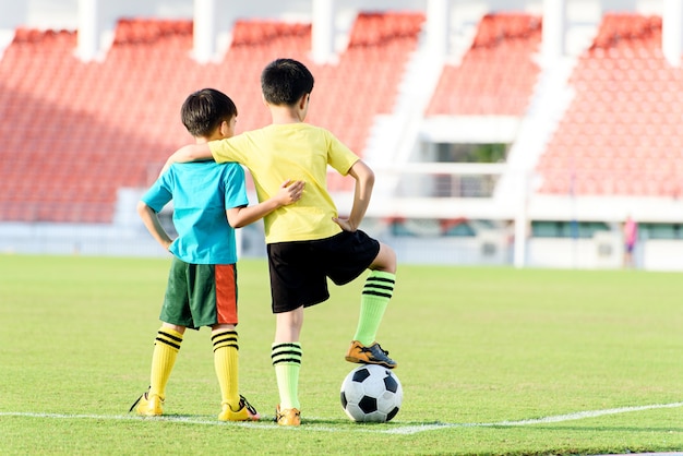 Garçon et football dans le champ d&#39;herbe de football