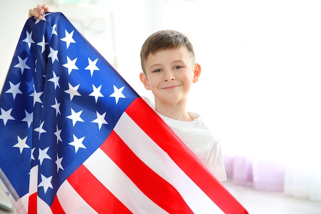 Garçon et grand drapeau américain dans la chambre