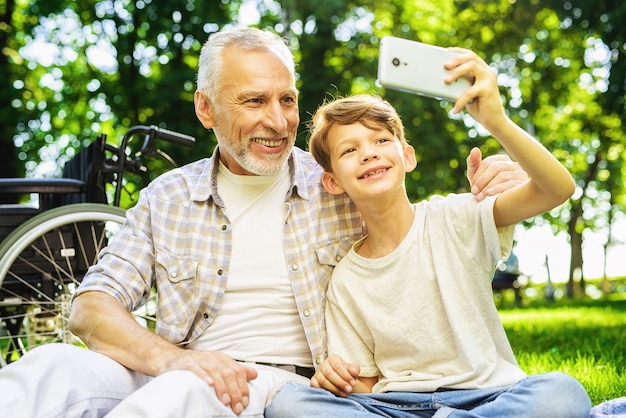 Le garçon et le grand-père fabriquent Selfie. Pique-nique familial.