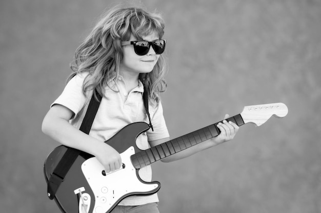 Garçon avec guitare Enfant joue de la guitare et chante de la musique et des chansons pour enfants