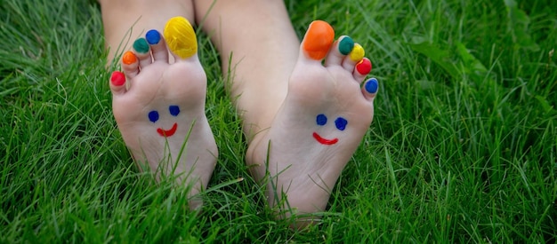 un garçon sur l'herbe avec un sourire peint sur ses pieds nature de mise au point sélective