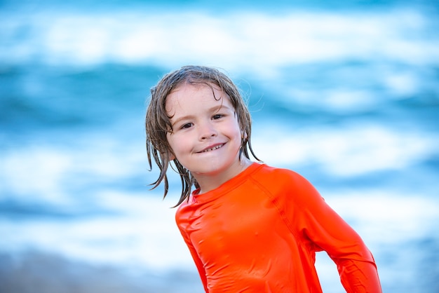 Garçon heureux d'enfants jouent dans la mer