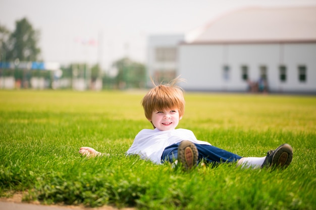 Garçon heureux sur l'herbe.