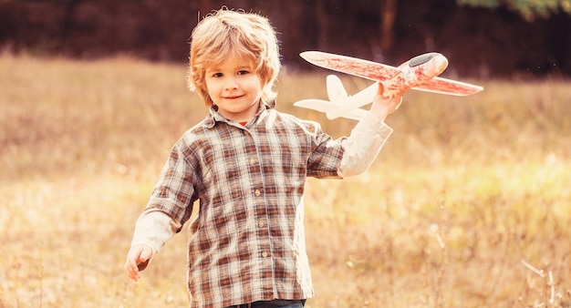 Un garçon heureux joue à l'avion Un petit garçon avec un avion Un petit enfant rêve d'être pilote