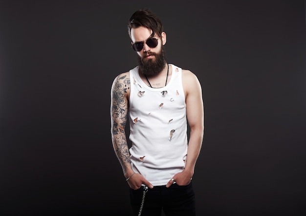 Garçon hipster barbu brutal à lunettes et chemise vintage