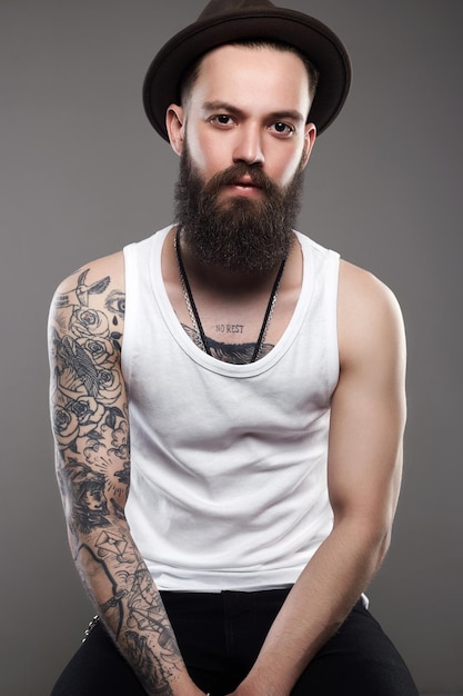 Garçon hipster brutal avec tatouage