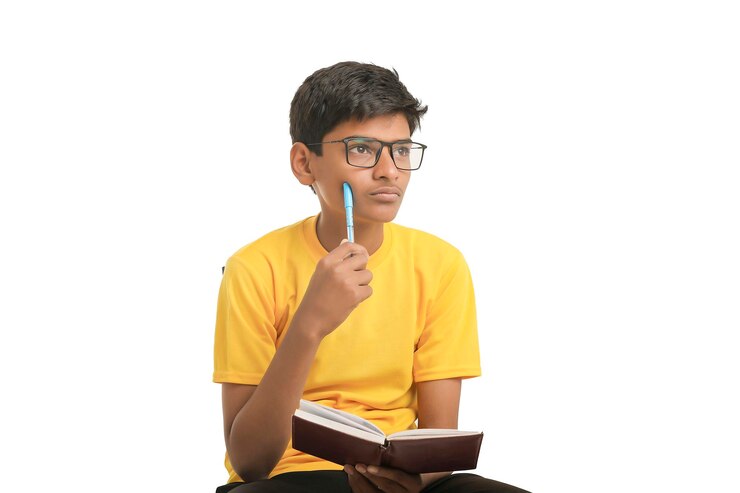Garçon indien tenant un journal à la main et pensant à une idée sur fond blanc