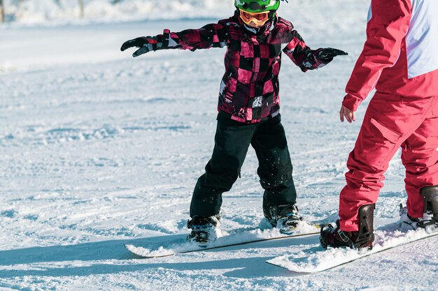 Garçon et instructeur sur la classe de snowboard