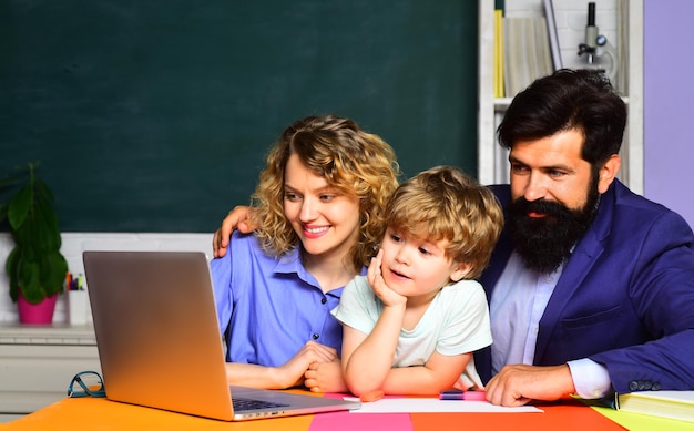 Garçon intelligent enfant mignon garçon avec les parents dans la salle de classe enfant se prépare pour l'école concept d'école femme