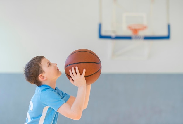Un garçon jouant au basket sur le terrain.