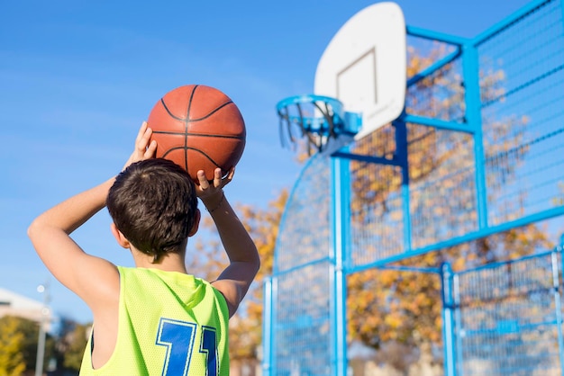 Un garçon jouant au basket sur le terrain.