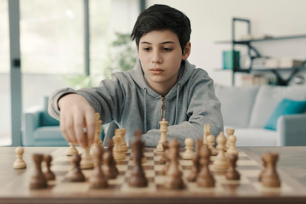 Garçon jouant aux échecs à la maison