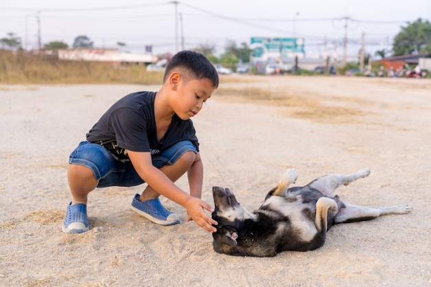 Garçon jouant avec des chiens noirs sur le sol