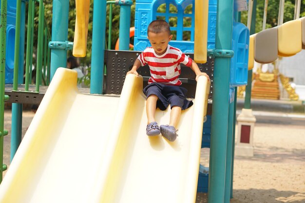 Garçon jouant dans l'aire de jeux du parc