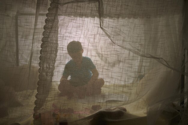 Garçon jouant dans la maison de la tente