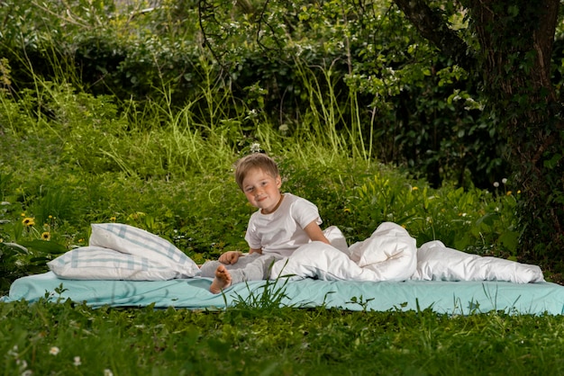 Garçon jouant sur le lit dans le jardin