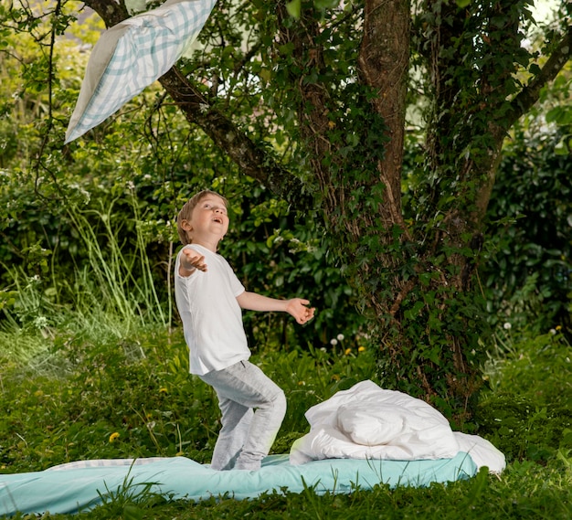 Garçon jouant sur le lit dans le jardin