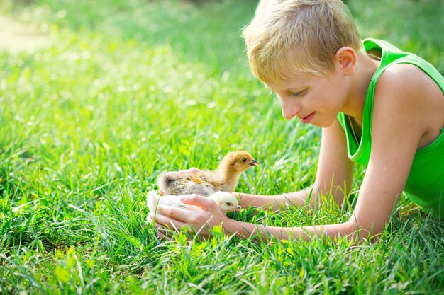 Garçon jouant avec des poulets dans le jardin