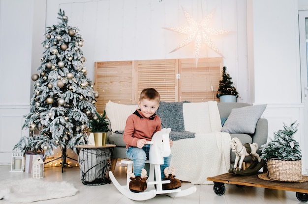 Garçon jouant près de l'arbre de Noël