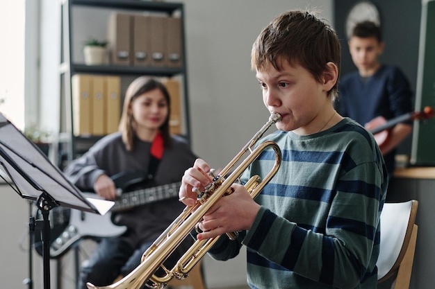 Un garçon jouant de la trompette dans l'orchestre de l'école