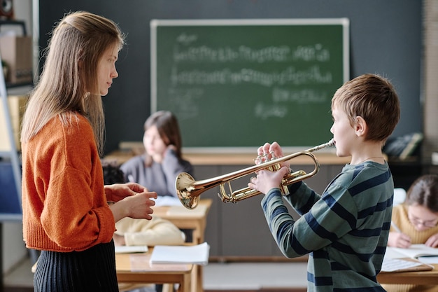 Un garçon jouant de la trompette à la leçon de musique