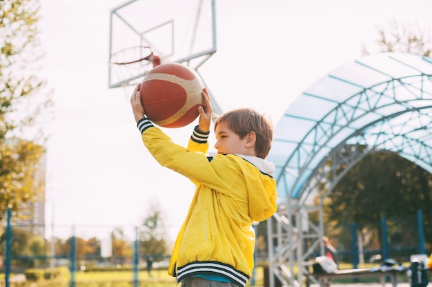 Photo un garçon joue au basket-ball sur le terrain.