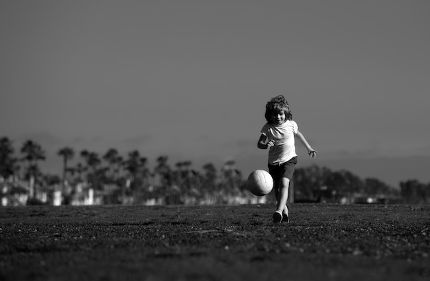 Un garçon joue au football sur un terrain de football, un enfant joue au football, des enfants s'entraînent au football.