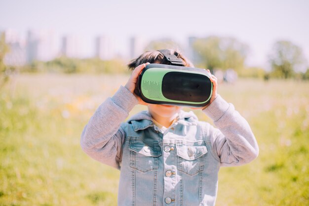 Un garçon joue aux lunettes de réalité virtuelle dans la rue Gadgets modernes Jeux pour enfants Le choix des lunettes virtuelles Un article sur les lunettes virtuelles Les enfants modernes