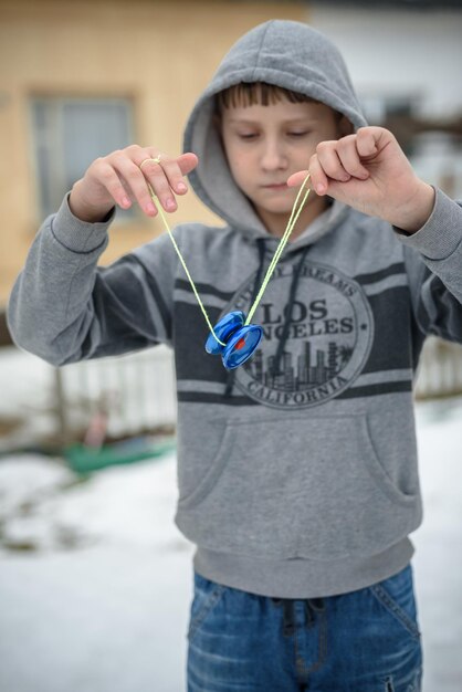 Un garçon joue dans la cour avec un yoyo