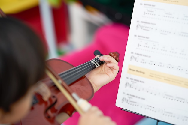 Garçon joue du violon avec corde d'arc avec copie espace sur fond flou, mise au point sélective et flou note debout