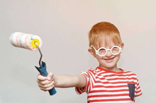 Photo garçon joue avec le rouleau pour la peinture