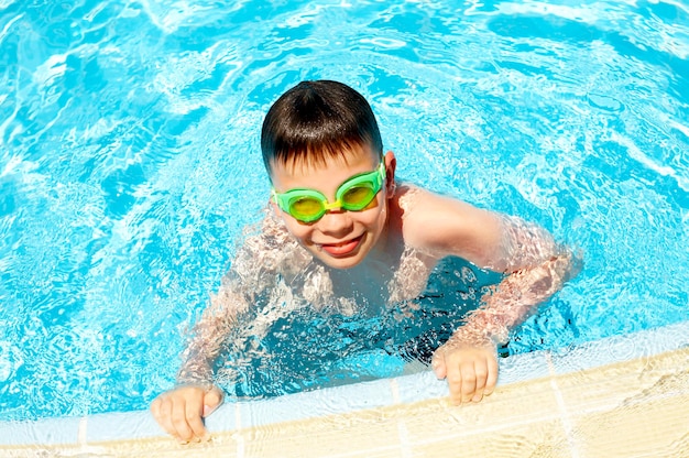 Le garçon joyeux dans la piscine