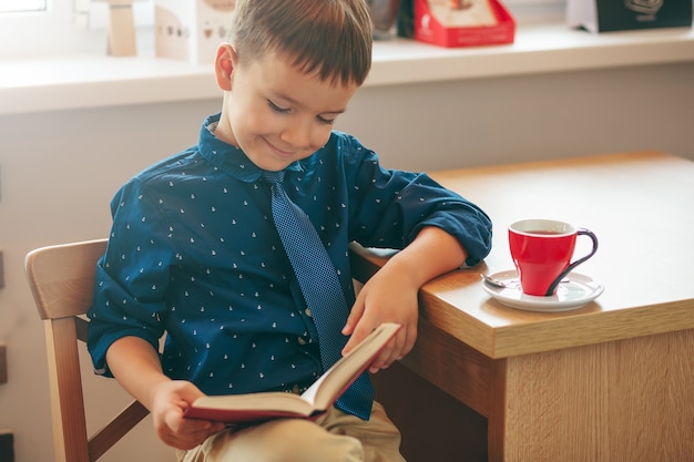 Garçon lecture, à, tasse thé