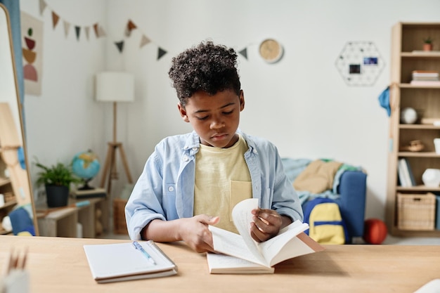 Garçon lisant un livre au bureau