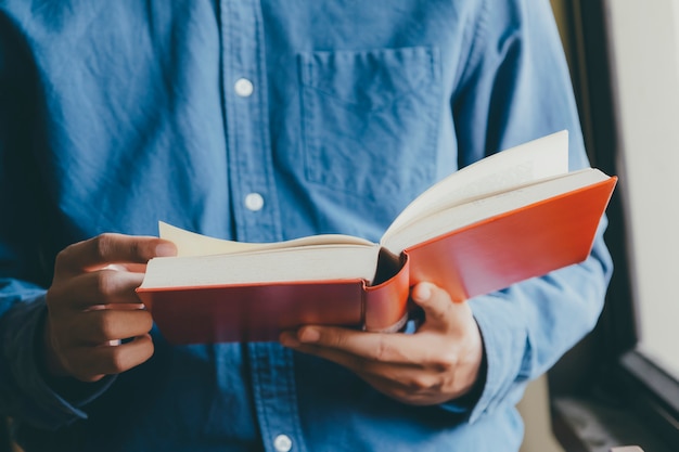 Garçon lisant un livre à la bibliothèque publique