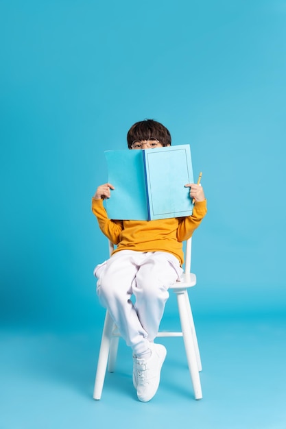 Garçon lisant un livre sur une chaise