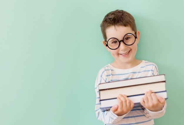 Un garçon à lunettes tient des livres collés