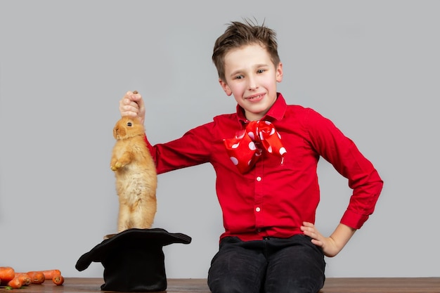 Un garçon magicien sort un lièvre de son chapeau