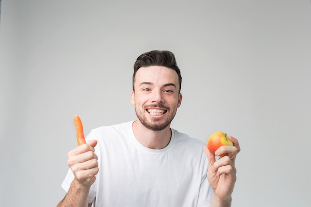 Garçon mange une carotte et une pomme