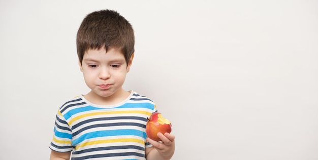 Un garçon mange une pomme