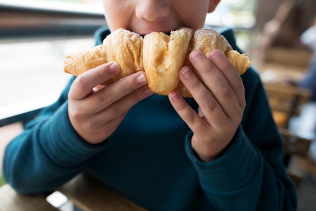 Garçon mangeant un croissant libre