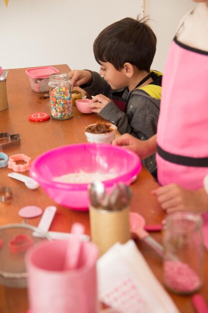 Un garçon mangeant un cupcake avec sa sœur à la table.