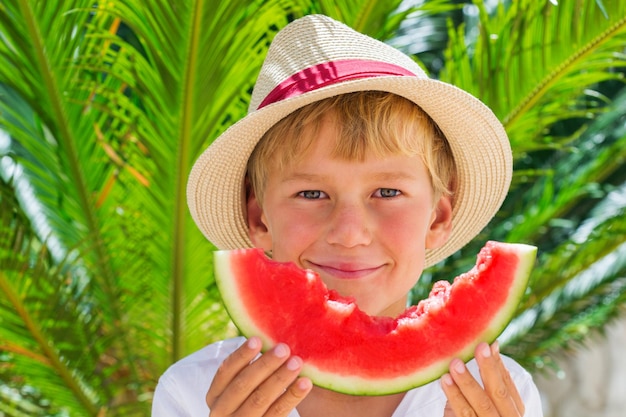 Garçon mangeant de la pastèque mûre rouge Concept de vacances et vacances d'été