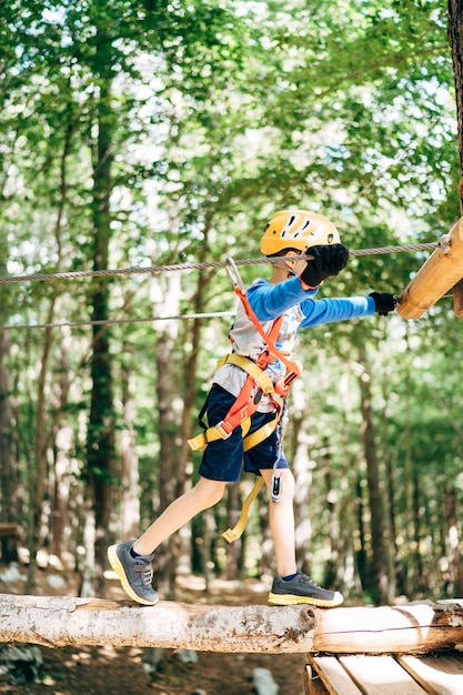 Le garçon marche sur le sentier aérien en bois jusqu'à la plate-forme en bois