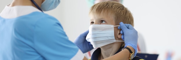 Garçon met un masque médical de protection au cabinet du médecin