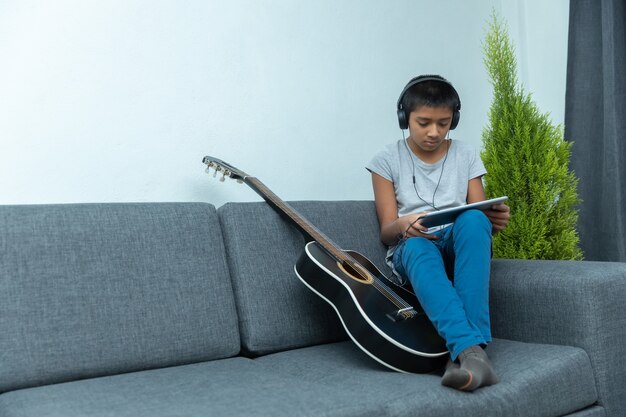 Un garçon mexicain prend des cours de guitare à la maison en raison du verrouillage du coronavirus et de l'enseignement à domicile