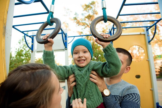 Un Garçon Mignon De 3 Ans Joue Avec Enthousiasme Sur Un Toboggan Jaune.